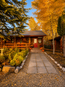 Fall leaves in the mountains behind a rustic cabin